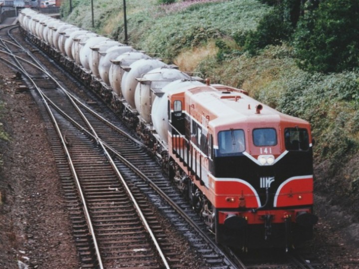1994: A freshly painted 141 was captured with this train of cement bubbles at Drogheda. The cutting side to the right of the picture was completely removed when the railcar servicing facility was built in 2004. (B.Pickup)