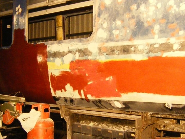 Master painter Joe Galbraith has the body side well rubbed down in preparation for a coat of primer.